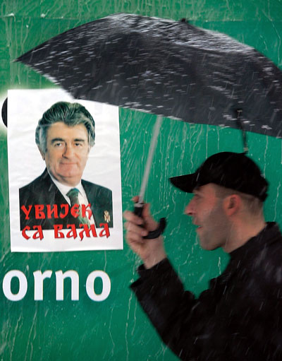 Un hombre camina al lado de un póster de apoyo al ex líder serbobosnio Radovan Karadzic en la ciudad de Banja Luka, entidad República Srpska. AFP/Getty Images 
