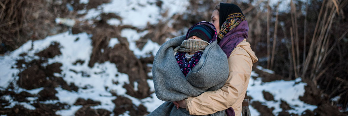 Una mujer refugiada camina mientras carga en brazos a su hijo en Macedonia. Armend Nimani/AFP/Getty Images