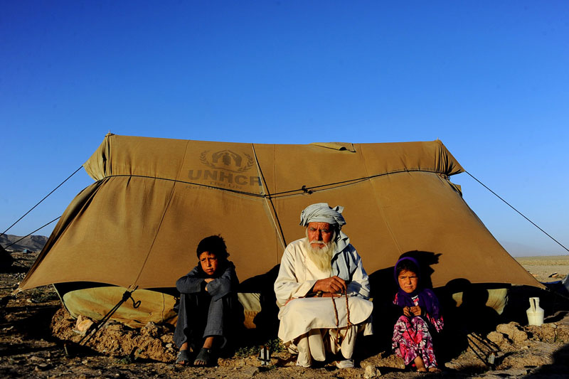 Afganistán. 124.000 nuevos desplazados. Total: al menos 667.000 (abril 2014 IDMC) Las cifras siguen en aumento, puesto que el número de nuevos desplazados ha continuado incrementándose a lo largo del 2013. Al menos la mitad de las personas que huyeron de sus hogares el año pasado se encontraban en la provincia de Helmad, al sur del país, donde 53.000 afganos abandonaron sus hogares. La población desplazada, cuyo 65% podría estar configurada por menores de 18 años, está estableciéndose frecuentemente en asentamientos informales en grandes ciudades sin ningún tipo de permiso de las autoridades. Hogares improvisados que no cubren las necesidades básicas y aumentan su vulnerabilidad, desplazados de larga duración con escasa esperanza de volver a donde se marcharon. De hecho, una encuesta llevada a cabo en 2012 afirmaba que el 75% de los desplazados internos afganos estaría dispuesto a integrase en sus lugares de refugio. La reciente política afgana sobre desplazamiento interno reconoce esta opción como una posible solución. En la foto, niños desplazados se sientan al lado de un hombre en una tienda de campaña instalada a las afueras de la ciudad de Herat. © Aref Karimi/AFP/Getty Images