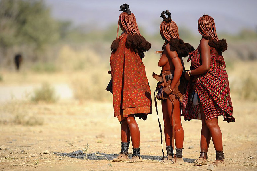 África. Ovahimbas. Nativos de la región de Kunene, al norte de la actual Namibia, los himbas son un pueblo seminómada, criadores de ganado y ascienden a 25.000. El colonialismo alemán y los posteriores conflictos del país con sus vecinos han afectado sensiblemente a esta tribu, la única que aún conserva el original estilo de vida que tenía hace algunos siglos. Actualmente, el incremento del turismo está acabando con el relativo aislamiento exterior que han mantenido hasta ahora. En la imagen, mujeres de la tribu himba en la carretera de Ohungumure, al noreste de Namibia. Stephane de Sakutin /AFP/Getty Images